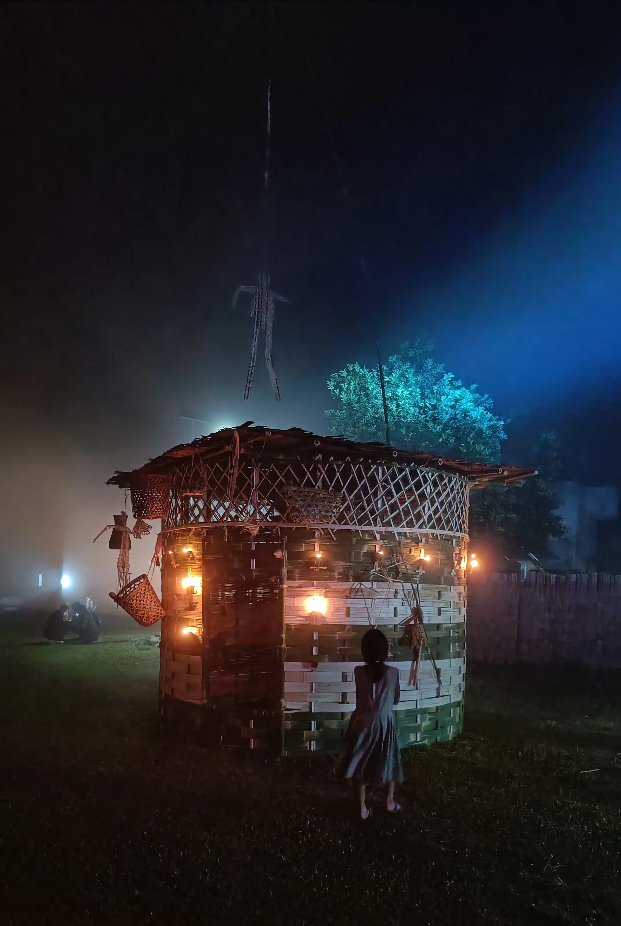 The woven bamboo installation lit at night